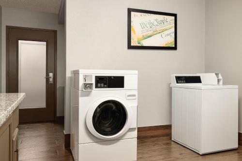 a washer and dryer in a white laundry room at AmericInn by Wyndham Madison WI in Madison
