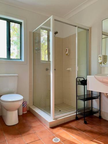 a bathroom with a shower and a toilet and a sink at Kangaroo Valley Golf and Country Retreat in Kangaroo Valley