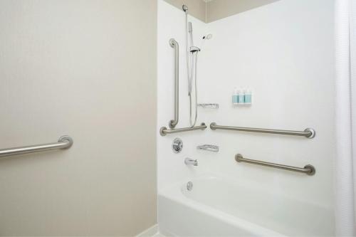 a bathroom with a shower with silver grab bars at SpringHill Suites by Marriott Gaithersburg in Gaithersburg
