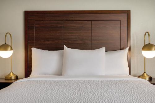 a bedroom with a large bed with two lamps at AmericInn by Wyndham Madison WI in Madison