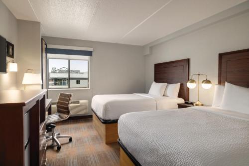 a hotel room with two beds and a window at AmericInn by Wyndham Madison WI in Madison