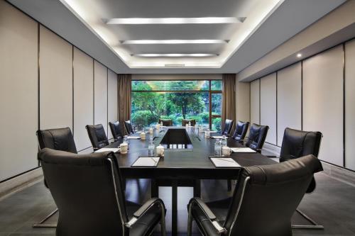 a conference room with a long table and chairs at 广悦华阳朔河畔酒店 in Gaotian