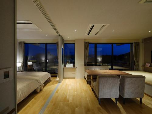 a bedroom with a desk and a bed and a table at Inasayama Kanko Hotel in Nagasaki