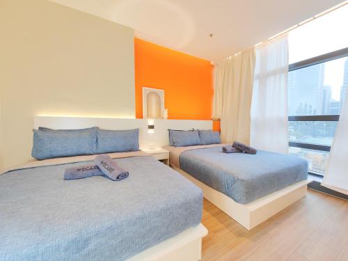 2 letti in una camera da letto con parete arancione di The Aspire - Bangsar Trade Centre a Kuala Lumpur