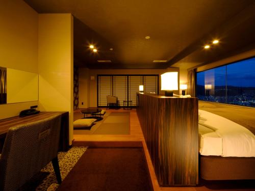 a bedroom with a bed and a large window at Inasayama Kanko Hotel in Nagasaki
