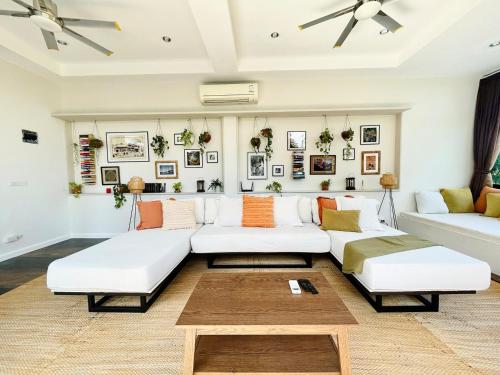 a living room with two white couches and a coffee table at Villa Mae - Gorgeous Thai Home with Amazing Pool in Ban Thung