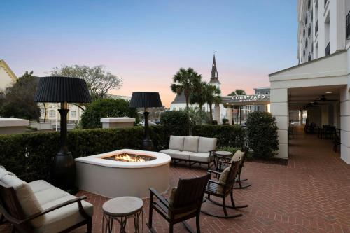 a patio with a fire pit and chairs and a building at Courtyard by Marriott Charleston Historic District in Charleston
