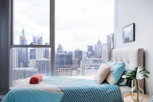 a bed in a room with a large window at Le Oasis Apt inCBD 2BR 3Beds near Southern cross in Melbourne