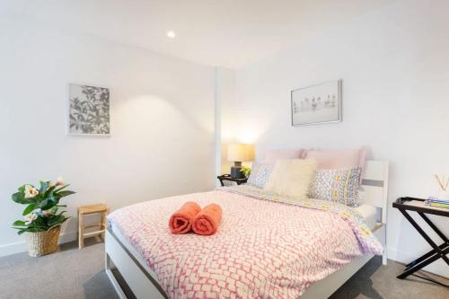 a bedroom with a bed with two orange slippers on it at Le Oasis Apt inCBD 2BR 3Beds near Southern cross in Melbourne