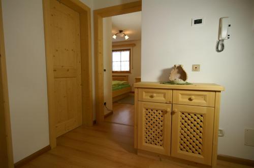 a room with a wooden cabinet and a hallway at Appartamenti Residence Pars in Badia