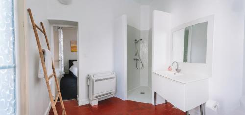 Un baño blanco con ducha y lavabo. en Demeure & Confort by Les Demeures de Rachel, en Nimes