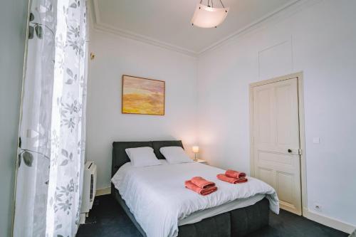 une chambre avec un lit blanc avec deux serviettes dessus dans l'établissement Demeure & Confort by Les Demeures de Rachel, à Nîmes