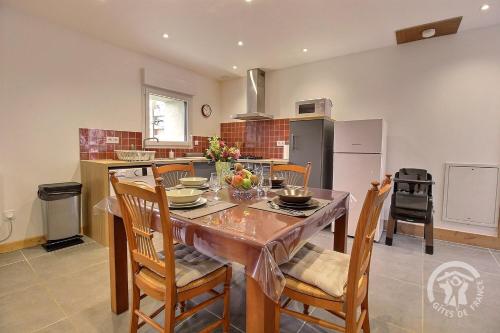 une cuisine avec une table avec des chaises et une salle à manger dans l'établissement Chez pauline, à Pléguien