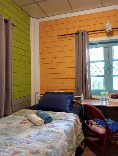 a bedroom with a bed and a table and a window at Young and Beautiful in Bangkok