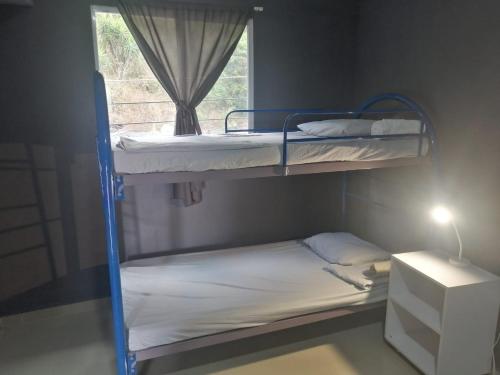 zwei Etagenbetten in einem Zimmer mit Fenster in der Unterkunft Apartamento Familiar 3 con 3 habitaciones 4 camas más litera in San Salvador