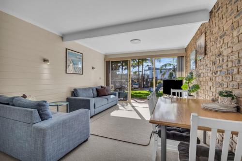 a living room with a couch and a table at Lakeside Apartments - Fishpen in Merimbula