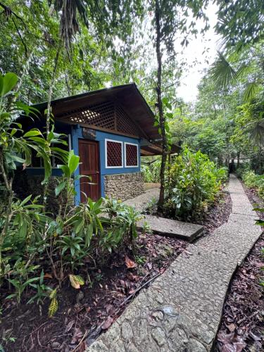 a small house with a blue door in a garden at Finca Tatin Hotel in Lámpara
