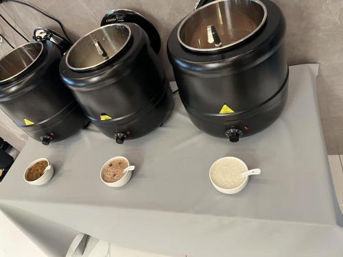 a stove with three pots and bowls of food at Country Inn&Suites by Radisson, Shanghai PVG in Shanghai
