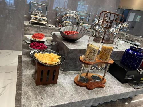 a kitchen counter with two vases and a bowl of fruit at Country Inn&Suites by Radisson, Shanghai PVG in Shanghai