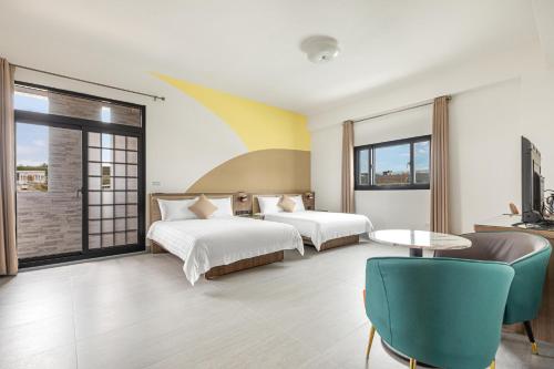 a hotel room with two beds and a table at 西里海岸 電梯民宿 in Magong
