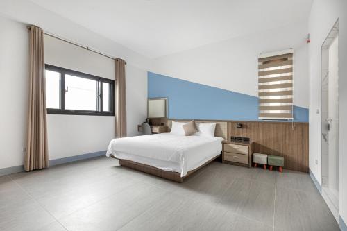 a bedroom with a bed and a large window at 西里海岸 電梯民宿 in Magong