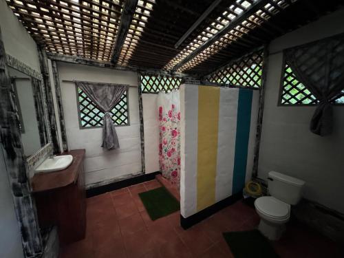 a bathroom with a sink and a toilet and windows at Finca Tatin Hotel in Lámpara