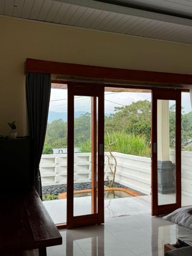 an open glass door with a view of a patio at Saris Sweet Dream Villa in Kubupenlokan