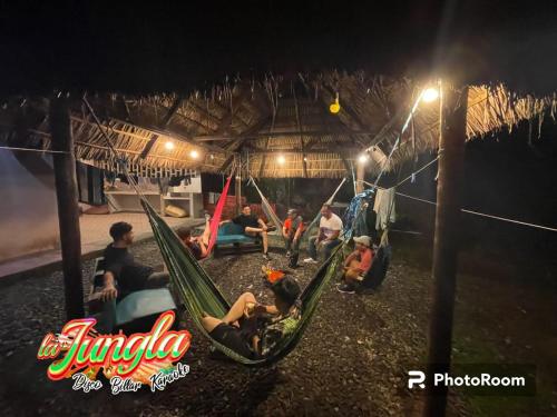 a group of people sitting in hammocks at night at LA JUNGLA Casa Vacacional in Puyo