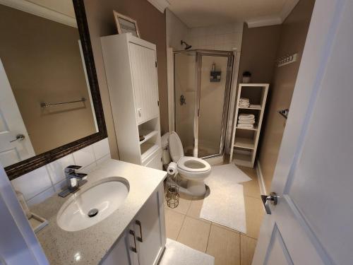 a bathroom with a toilet and a sink and a shower at Burnaby 4 bed 3 bath duplex in Burnaby