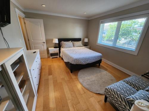 a bedroom with a bed and a window and a bed and a dresser at Burnaby 4 bed 3 bath duplex in Burnaby