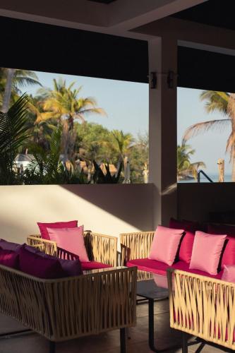 a room with chairs with pink and purple pillows at Privilege Suite by Apsara Resort in Koh Rong Island
