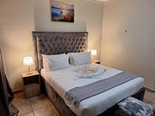 a bedroom with a large bed with white sheets at Menlyn Place City Vibes in Pretoria