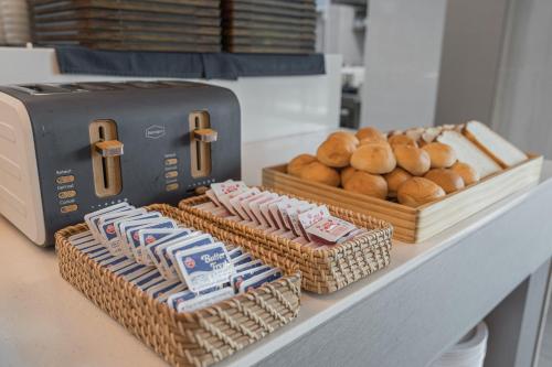 a counter with baskets of bread and a toaster at Act Hotel in Daegu