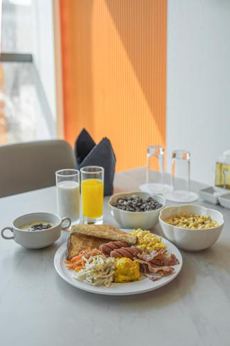 a table with a plate of breakfast foods and drinks at Act Hotel in Daegu