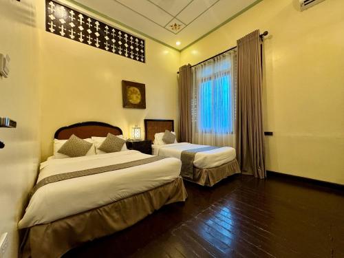 a hotel room with two beds and a window at Park Avenue Boutique Hotel Manila in Manila