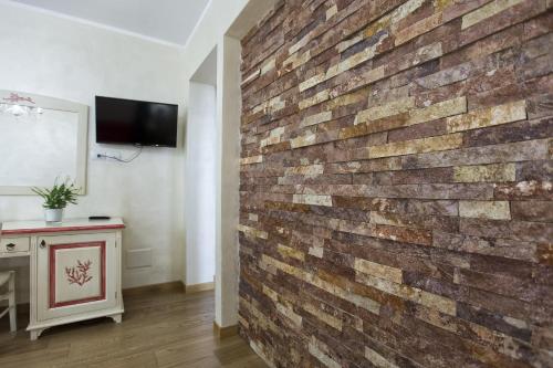 a brick wall in a room with a table at Morpheo Rooms in Alghero