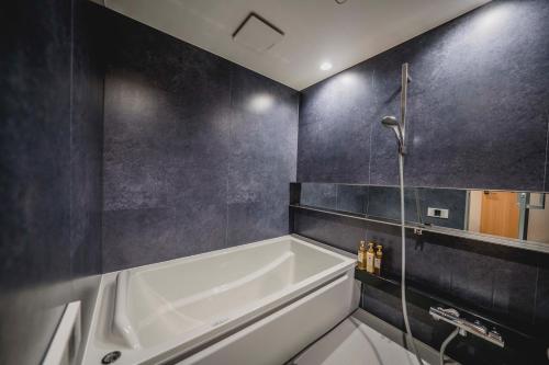 大阪hotel atarayo osaka的浴室配有白色浴缸和淋浴。