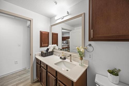 a bathroom with a sink and a mirror at Charming Frisco Apt with Pool & Gym in Frisco