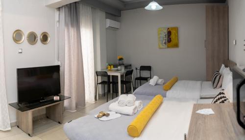a hotel room with two beds and a flat screen tv at Xenia_Apartments A7 in Kozani