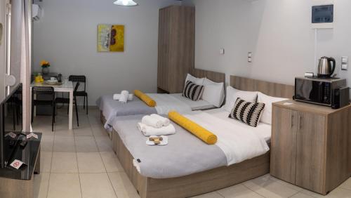 two beds in a room with a kitchen and a table at Xenia_Apartments A7 in Kozani