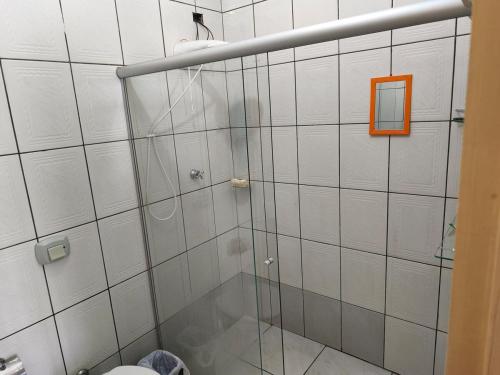 a shower with a glass door in a bathroom at Linda casa período Agrishow 2026 in Jaboticabal
