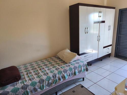 a bedroom with a bed and a dresser in it at Linda casa período Agrishow 2026 in Jaboticabal