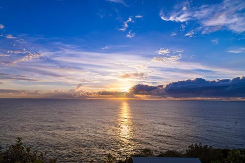 a sunset over a large body of water at Cliff Top Escape in Curl Curl
