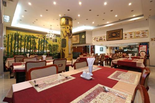 a dining room with tables and chairs and a restaurant at Diamond Residence Silom in Bangkok
