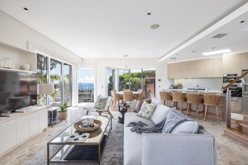 a living room with a couch and a table at Cliff Top Escape in Curl Curl