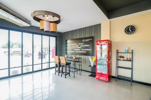 a restaurant with a red refrigerator and a table with chairs at King One Suvarnabhumi in Bangkok