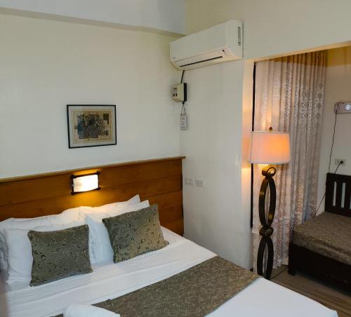 a hotel room with a bed and a lamp at Delle Suites in General Santos