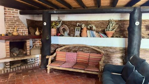 a living room with a chair and a fireplace at Xie-Hermosa cabaña con lago natural in Sáchica