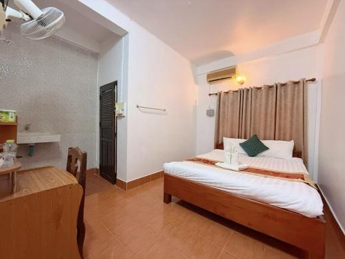 a bedroom with a bed and a desk in a room at Vangvieng Sisavang Mountain View Hotel in Vang Vieng