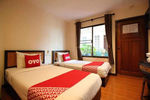 a hotel room with two beds and a window at Pannee Lodge Khaosan - SHA Plus in Bangkok